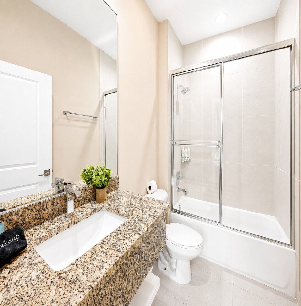 Full bathroom with granite vanity, glass-enclosed shower, soaking tub, and bright natural light