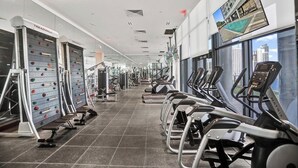Una palestra con tapis roulant, cyclette e pareti da arrampicata.