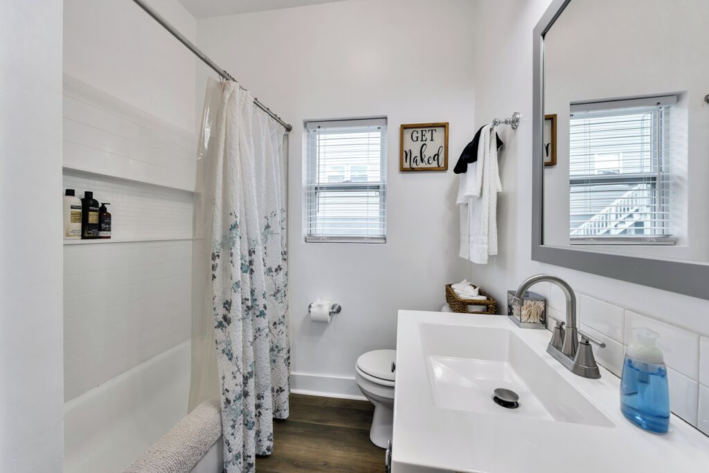 Ein Badezimmer mit Badewanne, Toilette, Waschbecken und Duschvorhang.
