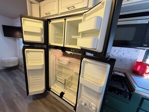 Una cocina equipada con refrigerador, microondas y estufa.