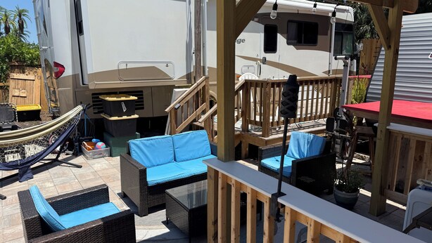 A covered outdoor area with wicker furniture, a hammock, and a wooden deck. - 2-bedroom RV in fantastic Clearwater with AC and some equipments for fitness (Clearwater)