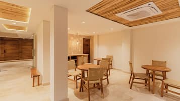 A modern interior with wooden furniture, a ceiling with a built-in air vent, and a hallway leading to a wooden door.