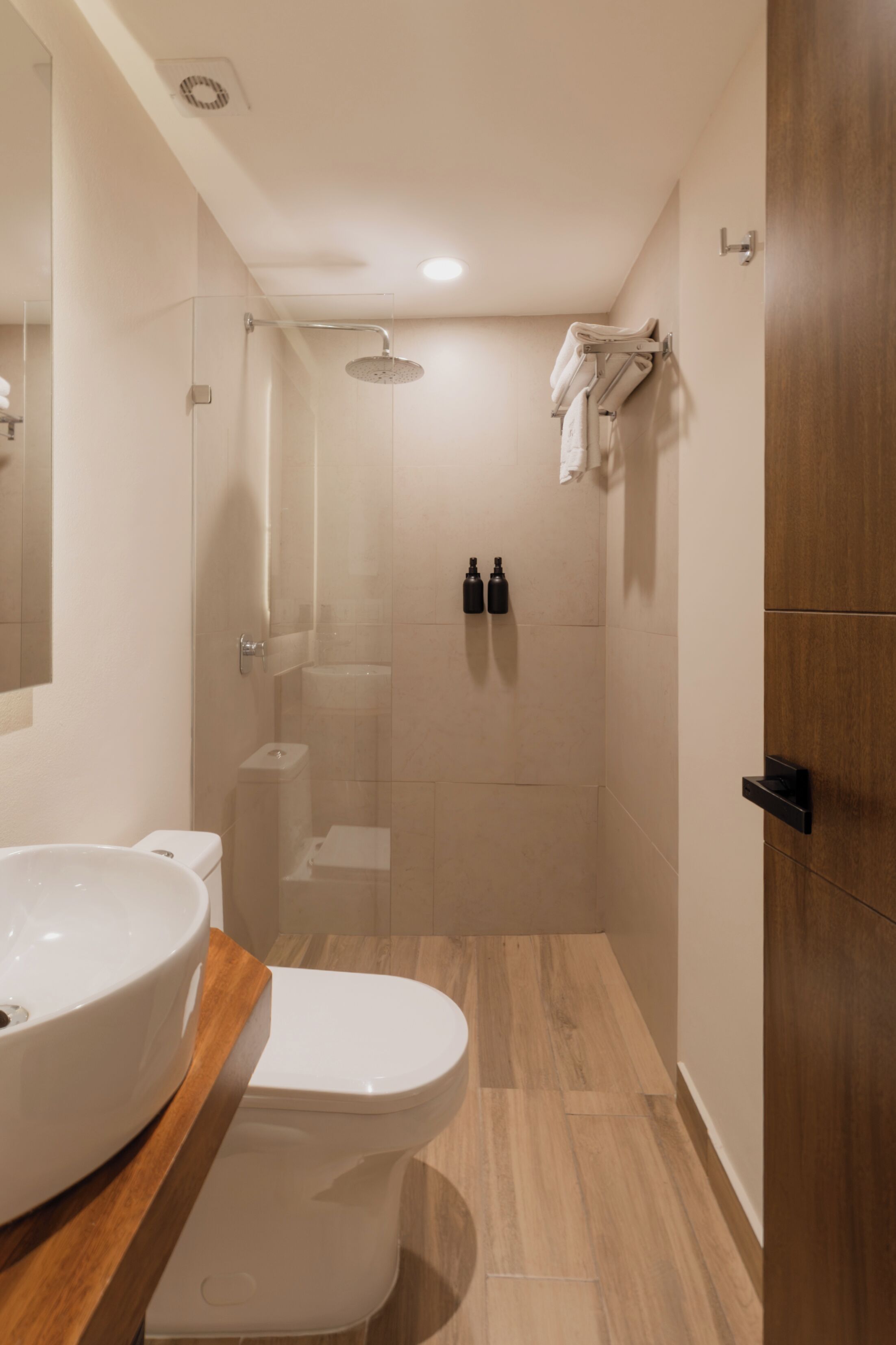 A modern bathroom with a large sink, toilet, and shower.