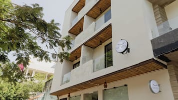 Un bâtiment moderne doté de nombreux balcons, de grandes fenêtres et d’une enseigne sur laquelle on peut lire « NIDARA ».