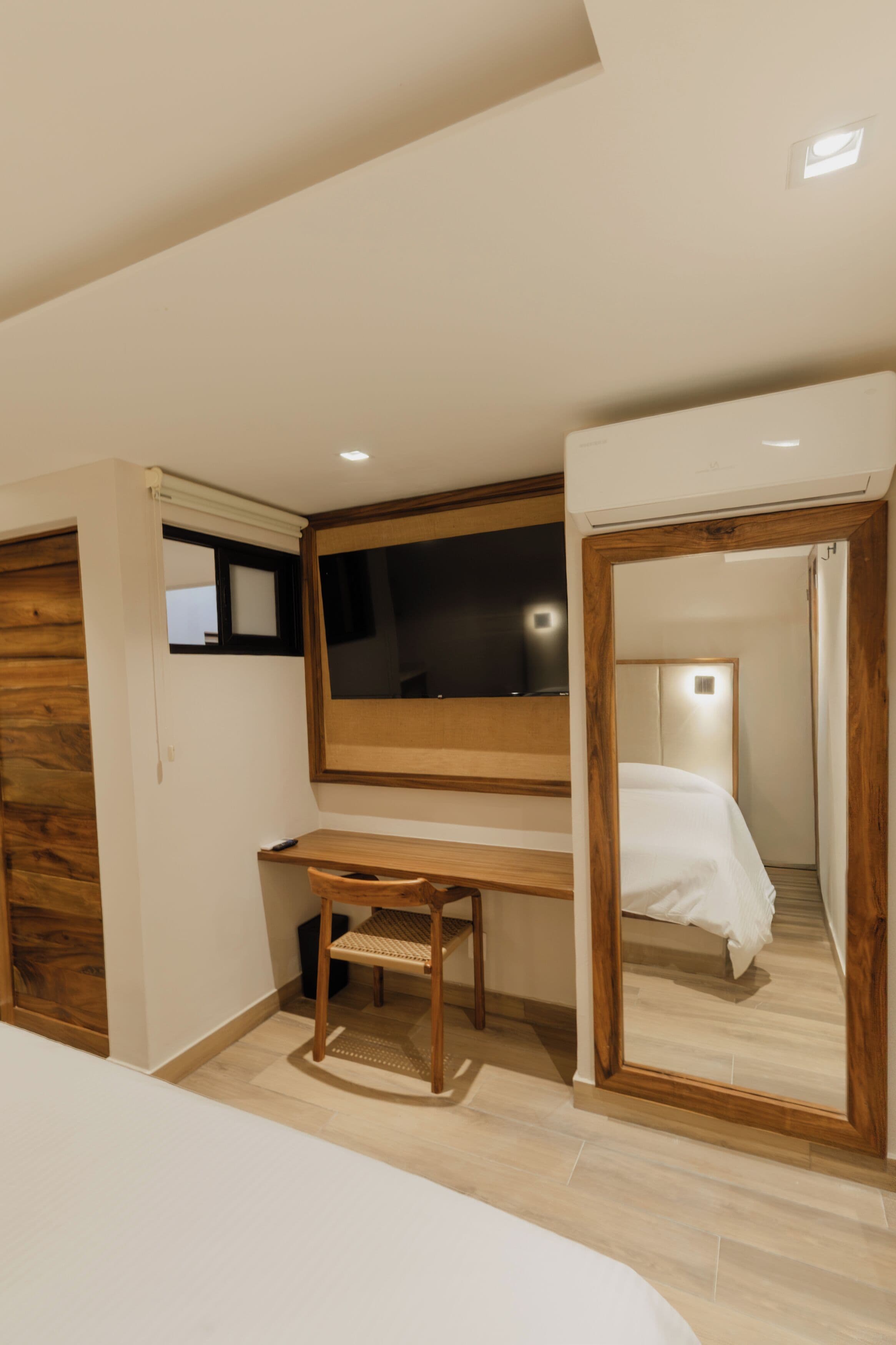 Une chambre à coucher avec un lit, un bureau et un miroir.