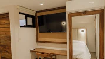 Une chambre à coucher avec un lit, un bureau et un miroir.