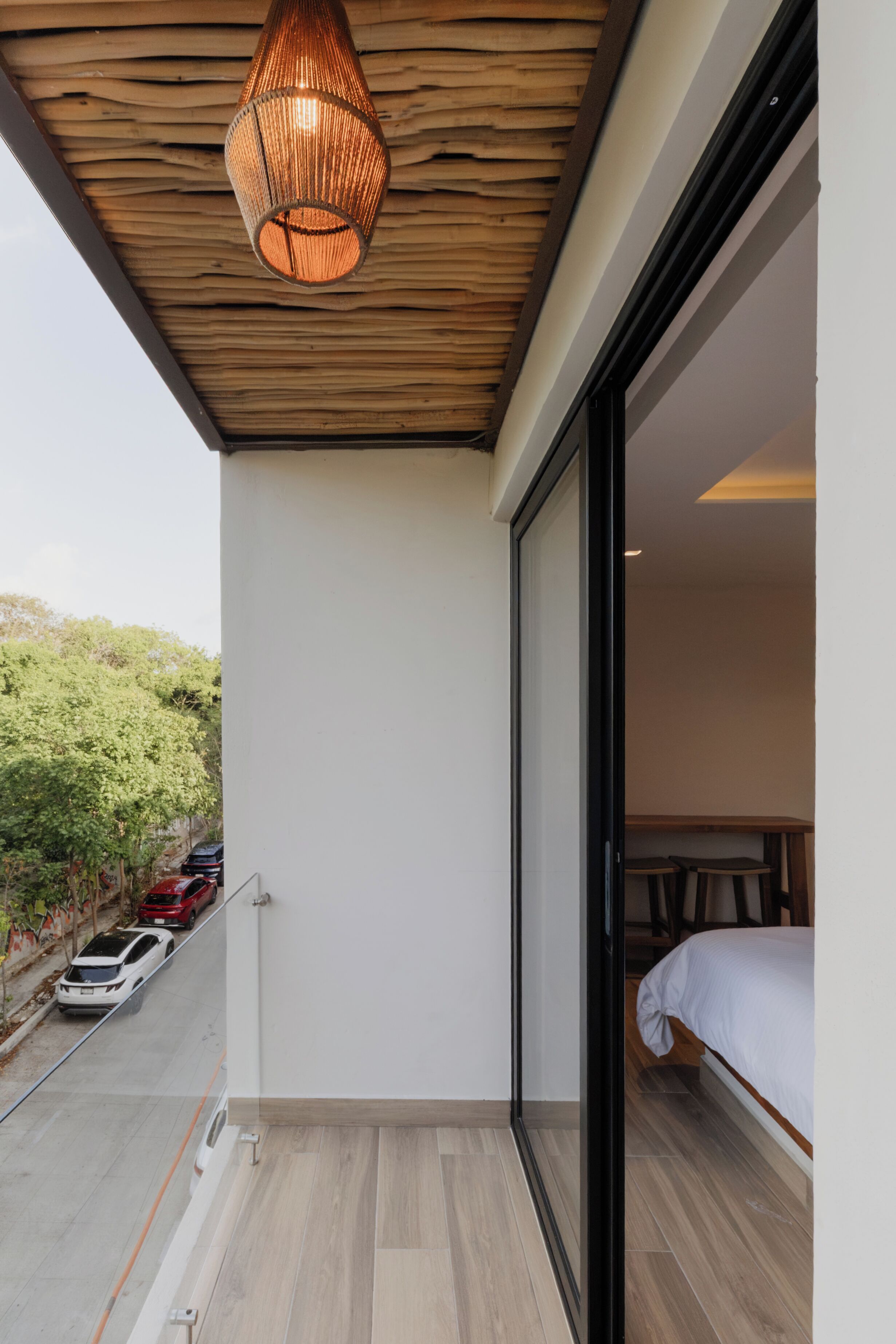 A balcony with a wooden ceiling and a hanging light fixture.