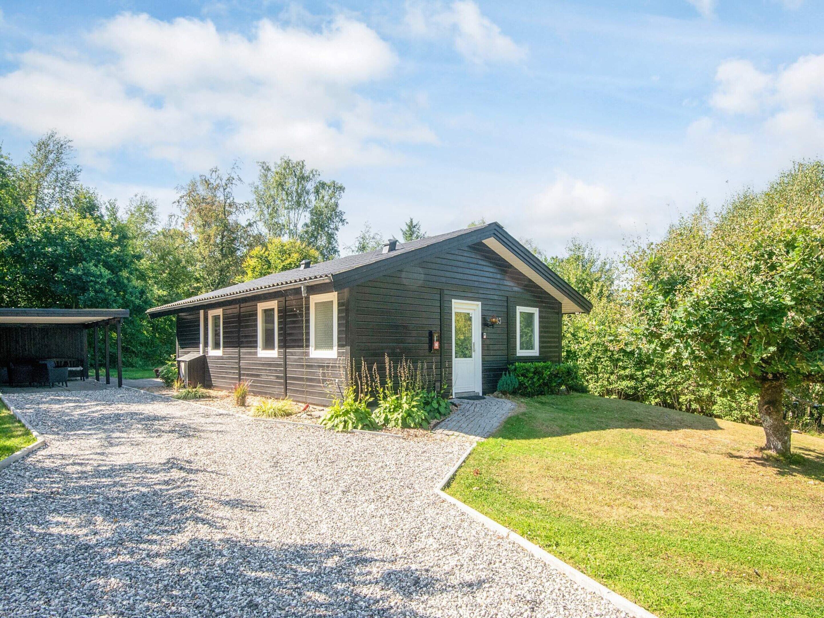 A single-story building with a gravel driveway and a covered outdoor seating area.