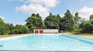 Ein rechteckiger Pool mit Fliesen umgeben.