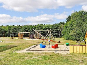 An outdoor playground with swings, slides, and climbing structures. - 4 Star Holiday Home in Farvang (Farvang)