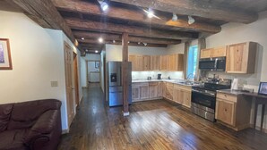 A kitchen with wooden cabinets, a refrigerator, a stove, and a microwave.