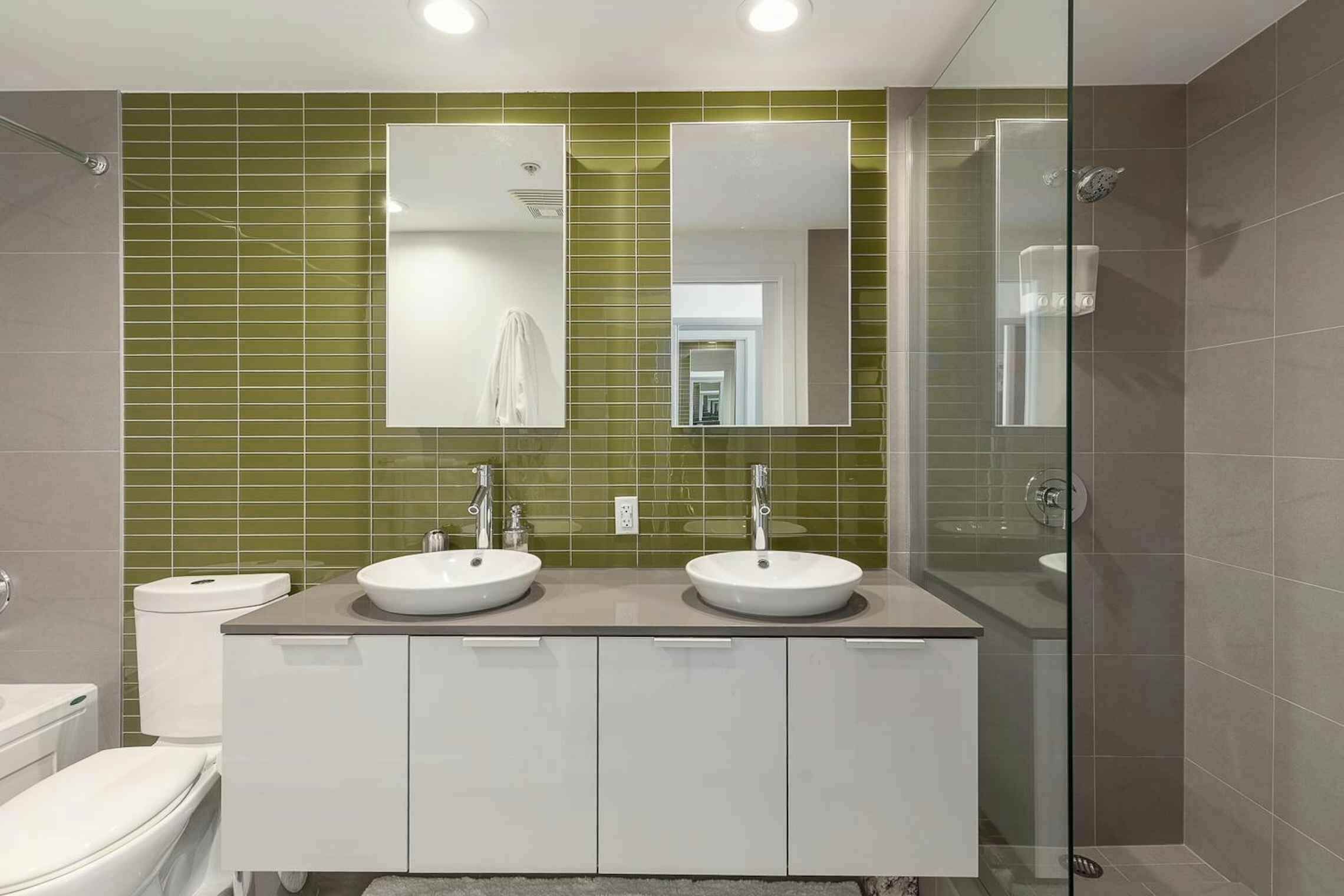 Ein Badezimmer mit zwei Waschbecken, einer Toilette und einer Dusche.