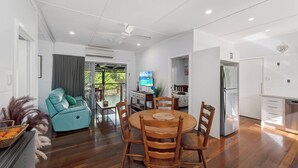 Een moderne woonkamer met een eetgedeelte, een keuken en een balkon met uitzicht.