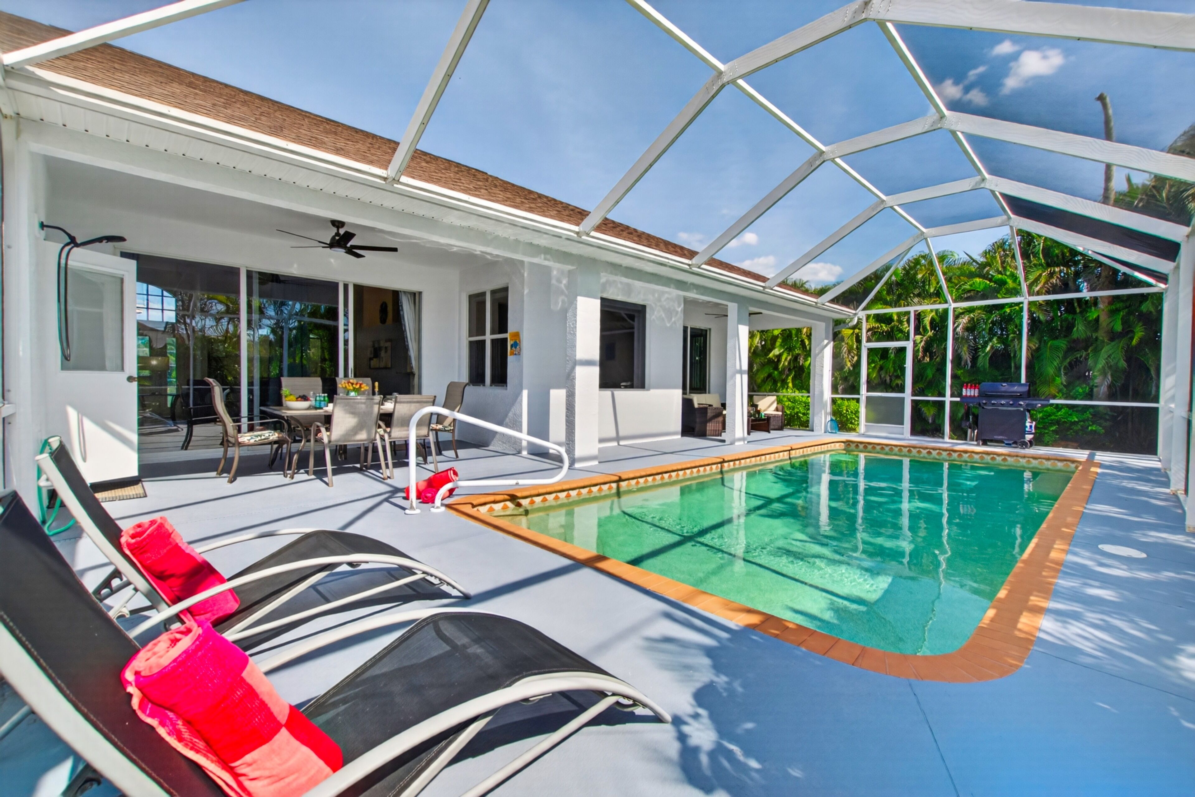 A covered outdoor swimming pool with lounge chairs and a patio area.