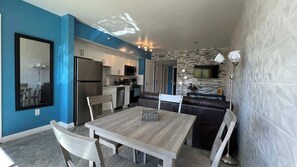 Et moderne køkken med spiseplads, køleskab, mikrobølgeovn og en backsplash med stengulvsmønster.