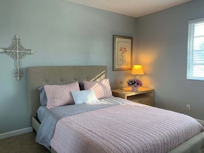 A bedroom with a bed, nightstand, lamp, and wall decor. - Spacious Modern Home - 4 miles from strip! (Las Vegas)