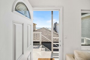 Ein Durchgang zu einem Balkon mit Blick auf den Strand und die Gebäude.