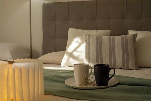 A neatly arranged bedroom with a bed, pillows, a cup, and a lamp. - Minerva Royal Suite - Alghero (Alghero)