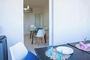A dining area with a table set for two, a chair, and a glass of water. - Minerva Royal Suite - Alghero (Alghero)