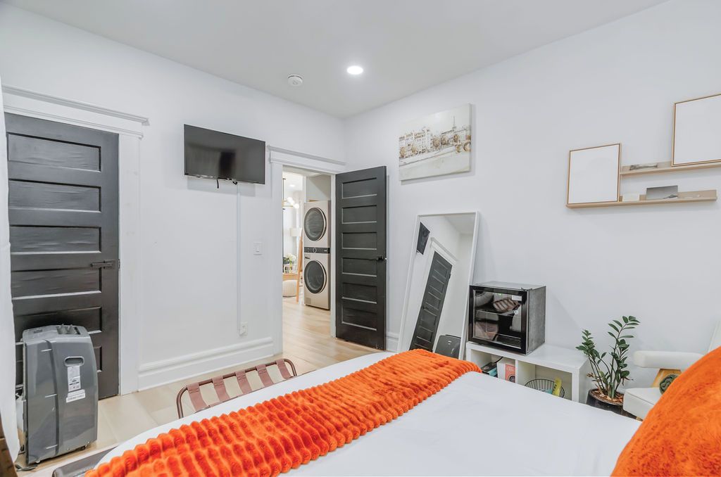 Un dormitorio con cama, televisión y armario.