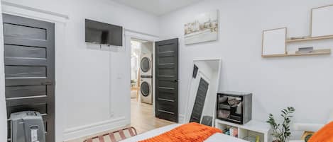 Un dormitorio con cama, televisión y armario.