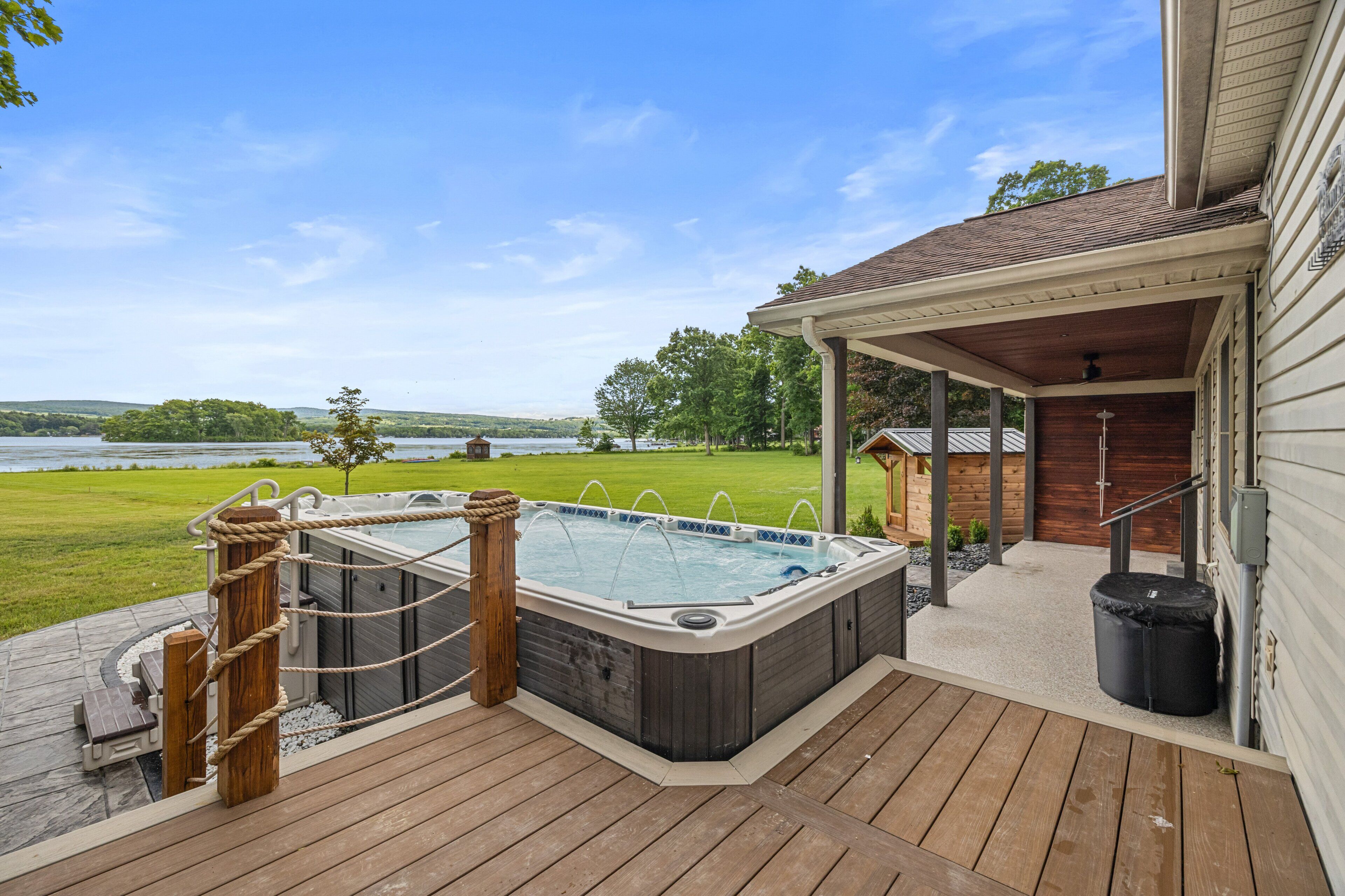 Un jacuzzi en una terraza de madera con vista a un lago.