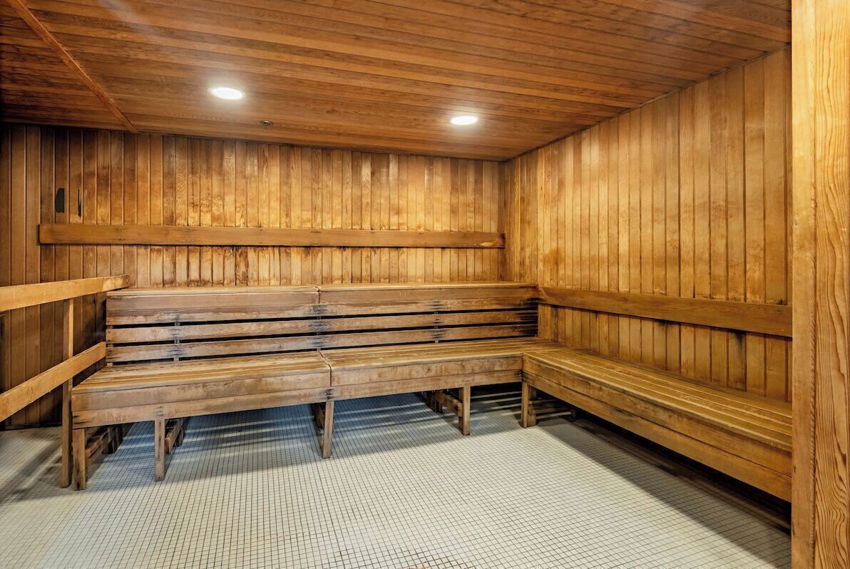 Un sauna avec des bancs en bois et un sol carrelé.