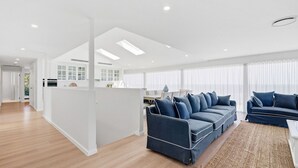 Een moderne woonkamer met een bank, een eethoek en een keuken.