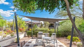 A patio with outdoor furniture, a grill, and a shaded area. - Just A Little Comfort (Scottsdale)