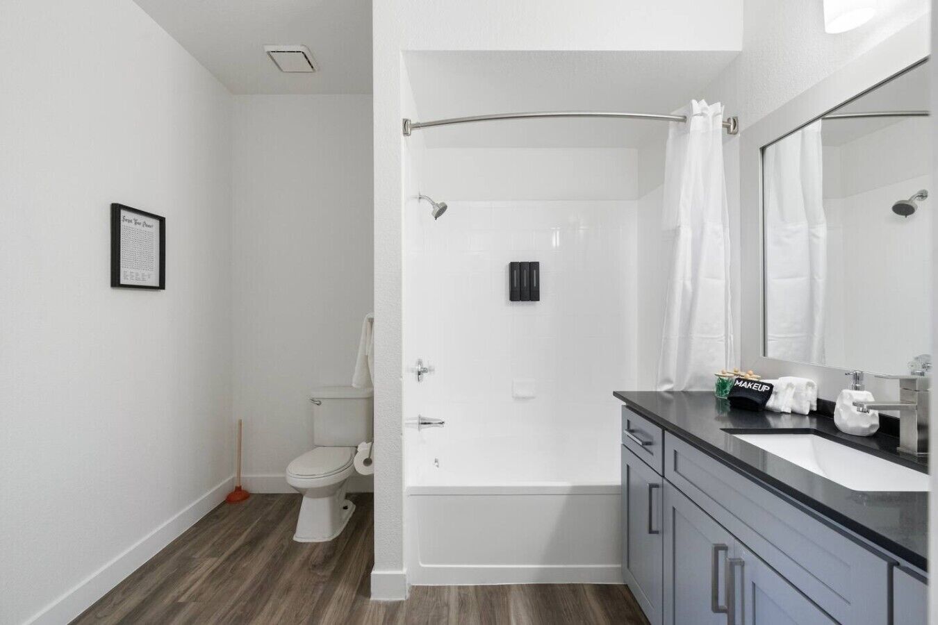 Une salle de bain moderne équipée de toilettes, d’une douche et d’un meuble-lavabo.
