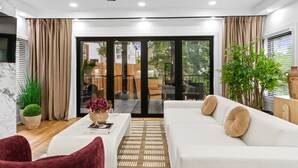 Ein modernes Wohnzimmer mit einer Couch, einem Couchtisch, einem Deckenventilator und einem großen Fenster.