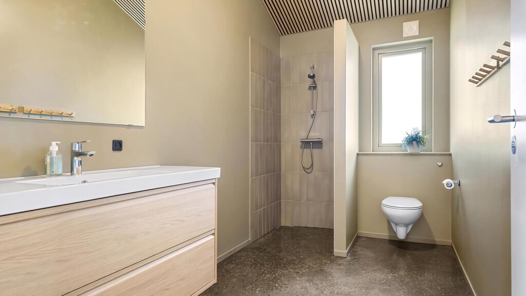 A bathroom with a shower, toilet, and vanity with a mirror.