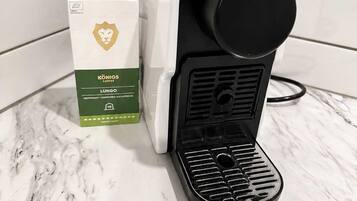Une machine à café, avec un carton de lait à côté, posée sur un comptoir en marbre.