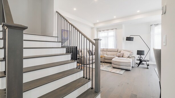 A modern interior with a staircase, a sofa, and a floor lamp. - Modern 4BR Home in charming Oakville (Oakville)