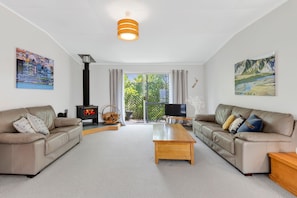 Ein Wohnzimmer mit zwei Sofas, einem Couchtisch, einem Kamin und Kunstwerken an den Wänden.