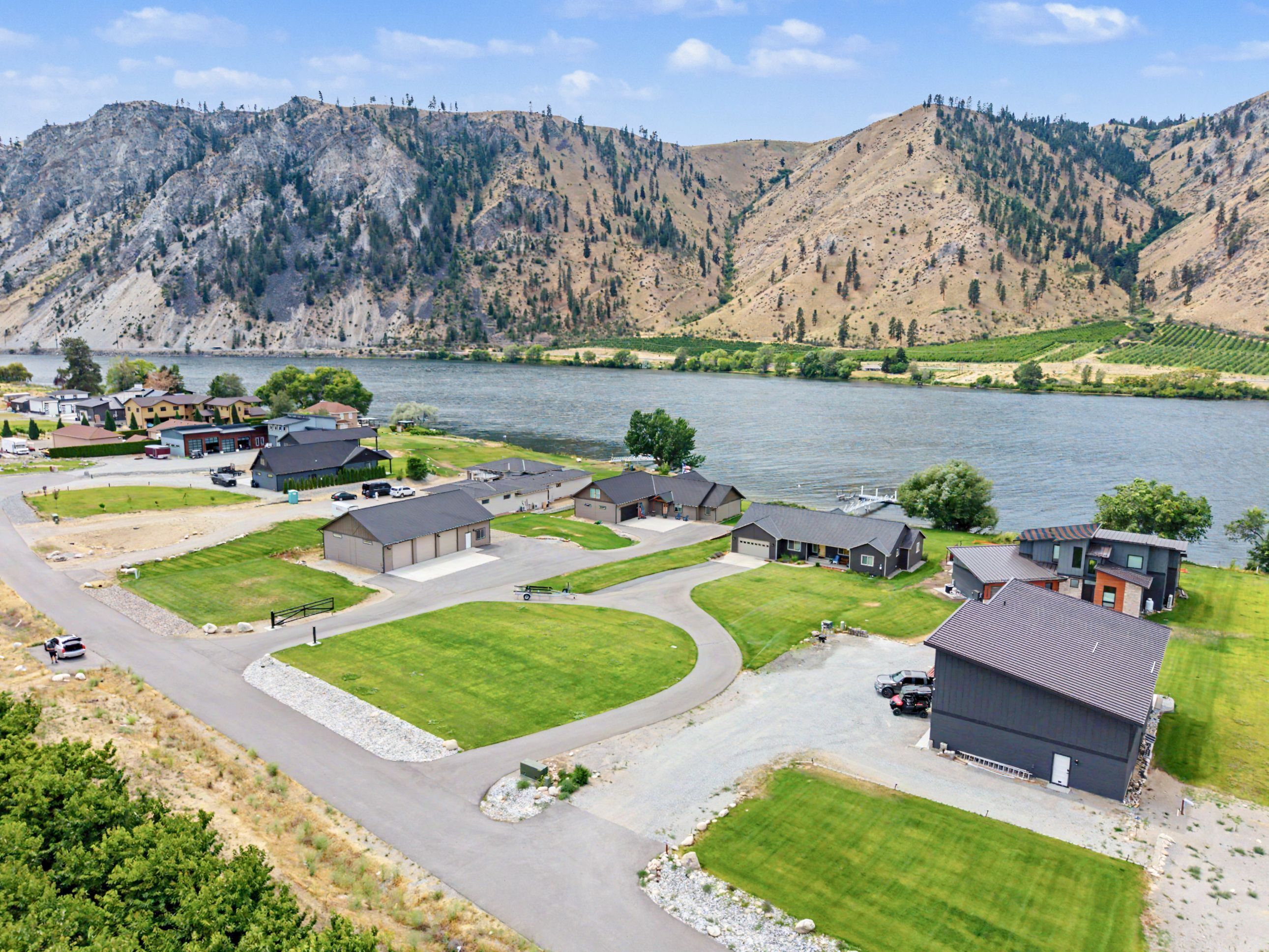 A residential area with houses, a driveway, and a lake.