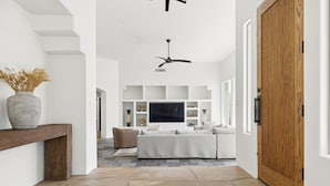 Et moderne interiør med klinkegulv, en træbænk, sofa, fjernsyn og en trädør.