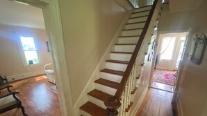 A wooden staircase with white walls and a wooden floor.