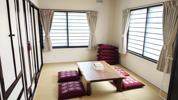 A traditional Japanese room with tatami flooring, a low wooden table, and shoji screens with curtains. - Minami Ward, Sapporo—10 or more people / Free shuttle service available / Perfect for groups and families with children! Free parking for 4 cars / We can arrange rental cars! (札幌市minami-ku,fujino)