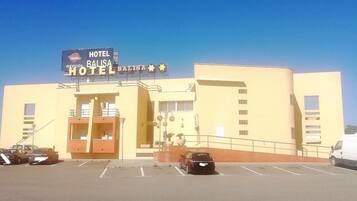 Hotel amb un rètol que diu 'HOTEL BALISA' i un aparcament al davant.