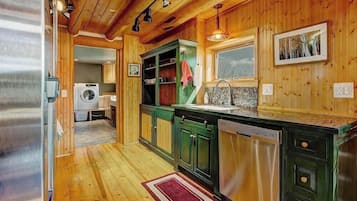 Une cuisine compacte avec des meubles en bois, un lave-linge encastré et une fenêtre.