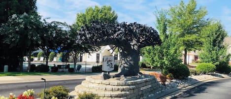 A landscaped area with a stone bench, a 'Relax & Gleam' sign, and a 'NO CLIMBING' sign.