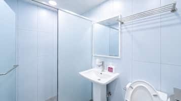 A bathroom with a white sink, a mirror, and a toilet.