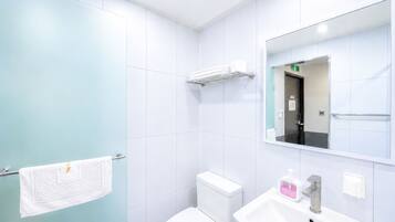 A modern bathroom with a toilet, sink, and mirror.