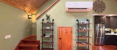 A staircase with wooden steps, a wooden door, and a wall-mounted air conditioner.