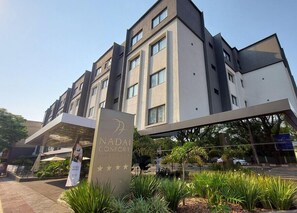 Um edifício moderno de hotel com uma placa que diz 'NADAI CONFORT HOTEL'.