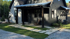 Une maison moderne dotée d’un porche abrité, d’un chemin en pierre et d’une allée en gravier.