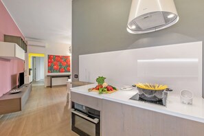 A modern kitchen with a built-in oven, a white countertop, and a pot of spaghetti. - Charme Nest | Luxury Suite Milan - Isola, Milano, Italy (Milano)