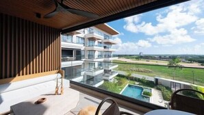 A balcony with a view of a modern building and a swimming pool.
