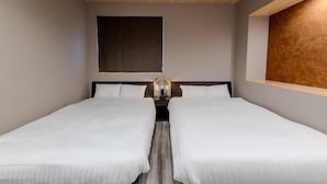 Habitación de hotel con dos camas individuales, un ventanal grande y techo de madera.